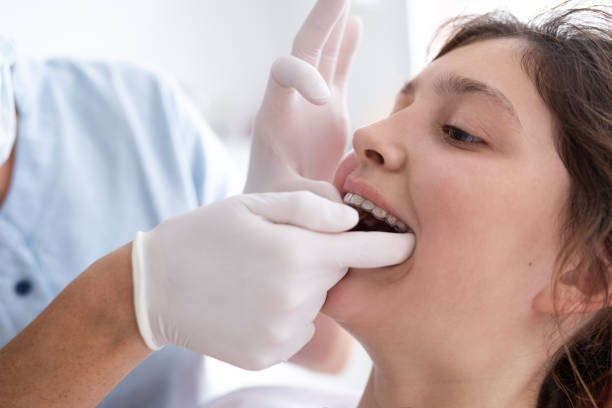 Dentist woman and teenager patient during dental consultation stock photo