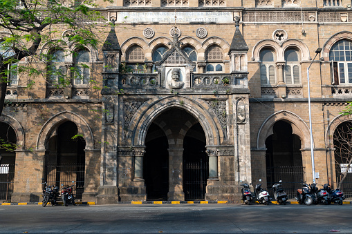 This image captures the essence of Kala Ghoda, a vibrant cultural precinct in Mumbai known for its rich artistic and architectural heritage. Kala Ghoda, which translates to 'Black Horse', is characterized by its array of heritage buildings, art galleries, boutiques, and cafes, all contributing to its distinctive charm. The photograph highlights the eclectic mix of neo-Gothic and art deco styles that define the area's architecture, set against the backdrop of contemporary urban life. This district is a hub for creative and cultural activities, hosting various events including the famous Kala Ghoda Arts Festival. The image aims to convey the unique blend of history, art, and culture that makes Kala Ghoda a must-visit destination for anyone exploring the diverse tapestry of Mumbai.