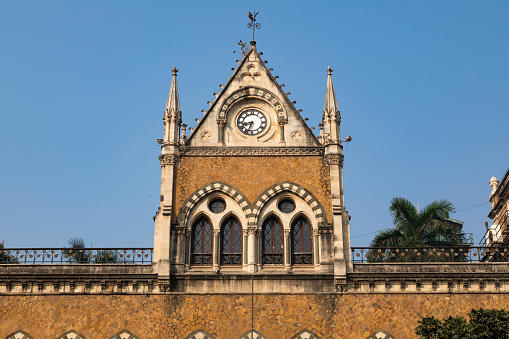 This image captures the essence of Kala Ghoda, a vibrant cultural precinct in Mumbai known for its rich artistic and architectural heritage. Kala Ghoda, which translates to 'Black Horse', is characterized by its array of heritage buildings, art galleries, boutiques, and cafes, all contributing to its distinctive charm. The photograph highlights the eclectic mix of neo-Gothic and art deco styles that define the area's architecture, set against the backdrop of contemporary urban life. This district is a hub for creative and cultural activities, hosting various events including the famous Kala Ghoda Arts Festival. The image aims to convey the unique blend of history, art, and culture that makes Kala Ghoda a must-visit destination for anyone exploring the diverse tapestry of Mumbai.