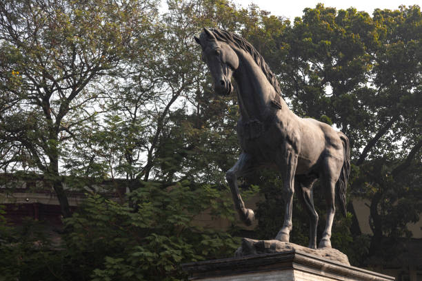 This image captures the essence of Kala Ghoda, a vibrant cultural precinct in Mumbai known for its rich artistic and architectural heritage. Kala Ghoda, which translates to 'Black Horse', is characterized by its array of heritage buildings, art galleries, boutiques, and cafes, all contributing to its distinctive charm. The photograph highlights the eclectic mix of neo-Gothic and art deco styles that define the area's architecture, set against the backdrop of contemporary urban life. This district is a hub for creative and cultural activities, hosting various events including the famous Kala Ghoda Arts Festival. The image aims to convey the unique blend of history, art, and culture that makes Kala Ghoda a must-visit destination for anyone exploring the diverse tapestry of Mumbai.