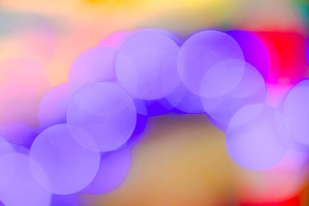Abstract blurry purple soft bokeh light circles glowing on colorful background, close up