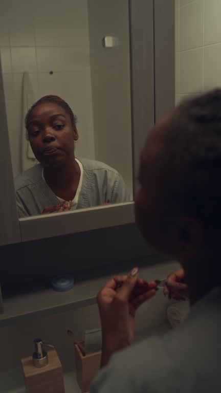 Black Hospital Nurse Flossing Teeth before Leaving for Work