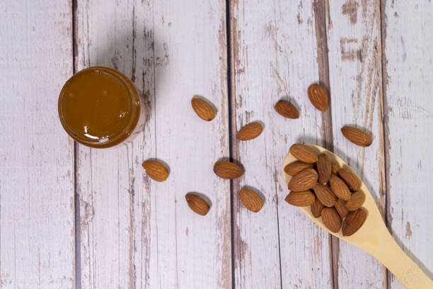 istock honey dripping on almond nuts isolated on white background 1825524350