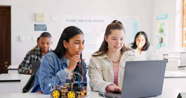 istock Robotics, education and children with laptop at school learning coding, robot or car toy. Girl students in classroom for technology, electronics or science for development, innovation or teamwork 1825633761