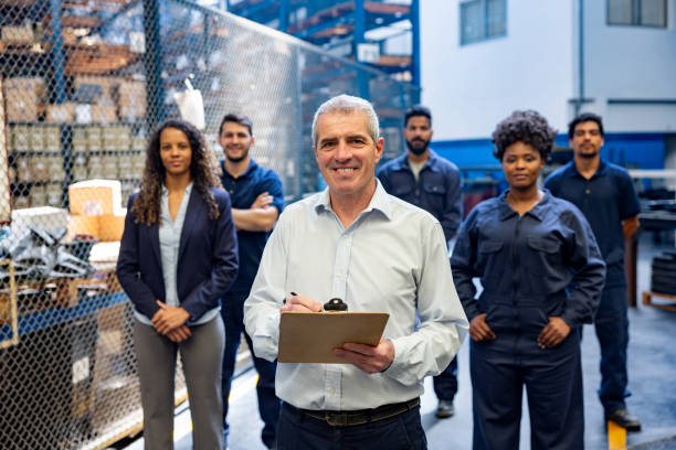 istock Business manager at a distribution warehouse with a group of employees 1825644882
