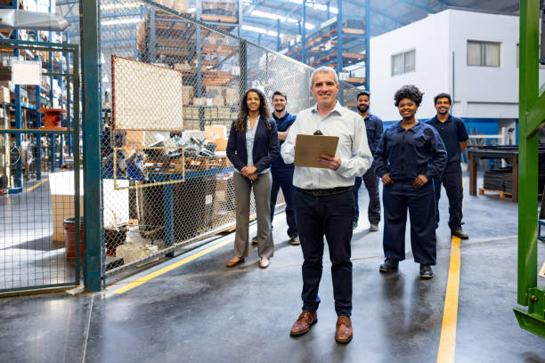 istock Foreperson smiling at a distribution warehouse with a group of employees 1825644888