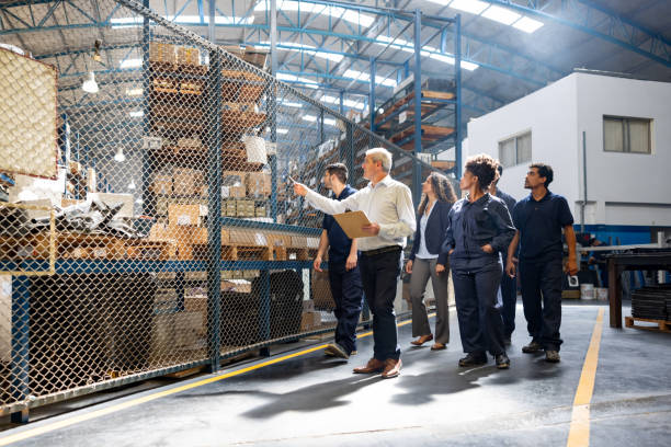 istock Foreperson at a distribution warehouse training a group of new employees 1825644891