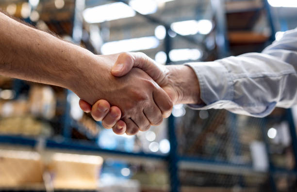 Warehouse manager hiring an employee and handshaking his hand Warehouse manager hiring an employee and handshaking his hand - business concepts working class stock pictures, royalty-free photos & images