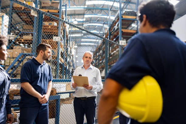 istock Foreman talking to a group of workers at a distribution warehouse 1825645430