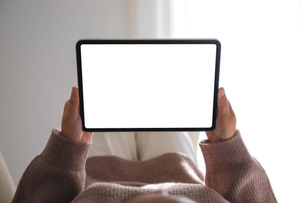 istock Mockup image of a woman holding digital tablet with blank desktop white screen while laying on a bed 1825711896