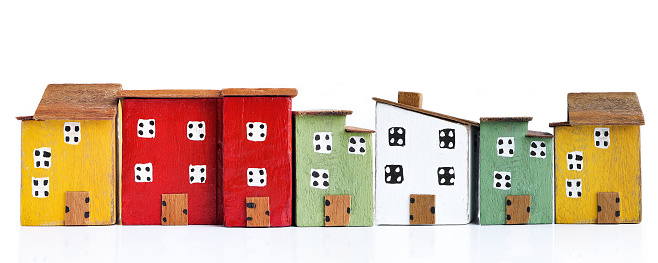 Different Size Houses In Row On Wooden Table