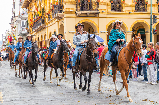 Cuenca, Ecuador - October 28, 2023: Independence Day celebration. A large group of ranchers and farm workers at a horse parade in the historic center of Cuenca