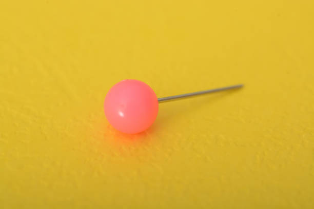 istock Pink pushpin isolated on a yellow background. 1825778437