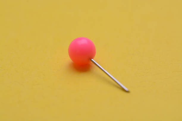 istock Pink pushpin isolated on a yellow background. 1825778954