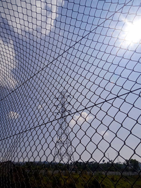 istock wire mesh fences and distant power towers 1825864051