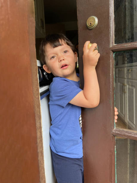 istock Little boy holding the door 1825895529