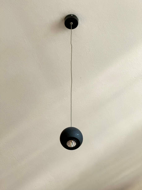 istock a lamp hanging from the ceiling with a black shade 1825935247