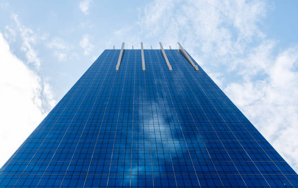 istock Bottom up view modern office building with glass window on blue sky background 1825940584