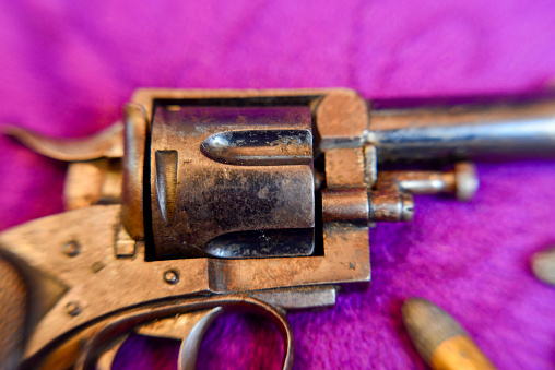 Very old hand gun on wooden planks, shot from upper view