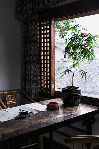 Traditional japanese machiya house or ryokan restaurant with black lacquered wooden table, cushion pillows and sliding paper doors with natural bright light