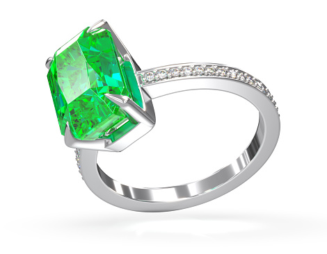 Ring with diamonds and emerald on white background.