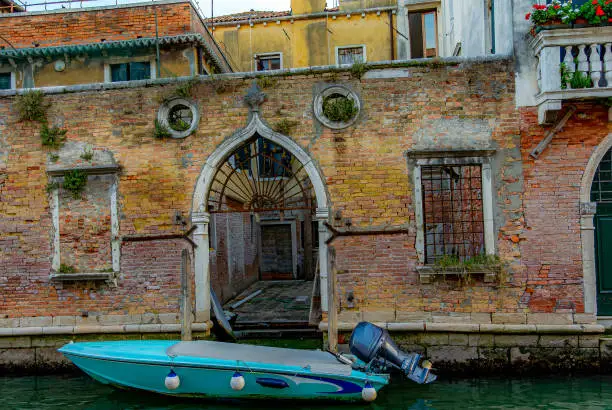 Photo of Venice canal motor boat on the water in front of old buildings