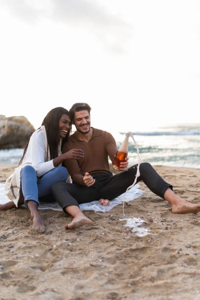 istock Couple pouring out champagne on the beach 1826215954