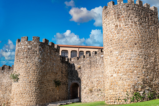 Muralla medieval restaurada del siglo XV y puerta de acceso a la villa de Plasencia con nubes, España