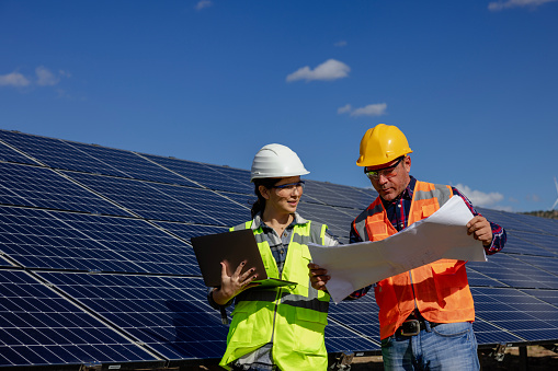 Solar panel and engineer workers working on a farm on clean electricity.