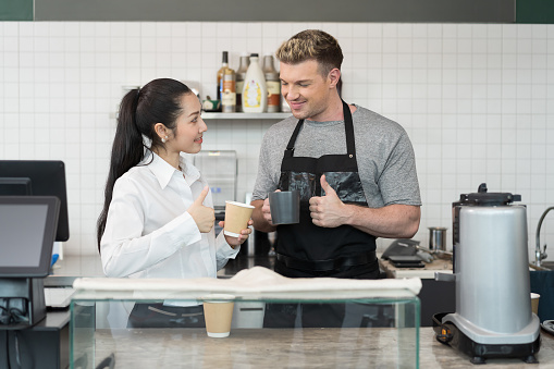 Barista cafe making coffee at coffee shop. Worker making coffee on steam espresso coffee machine. Small business concept