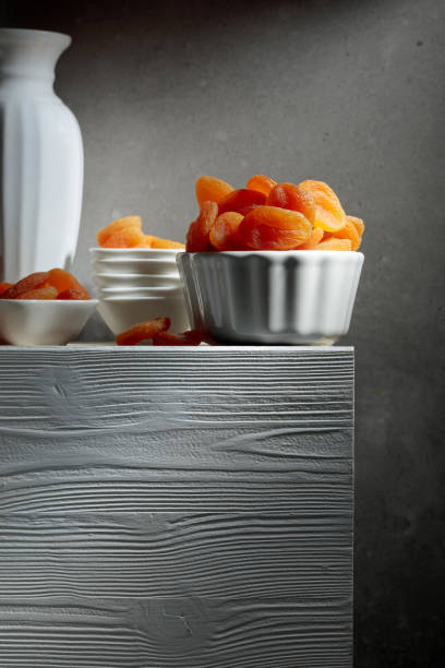 Dried apricots on a white wooden table.