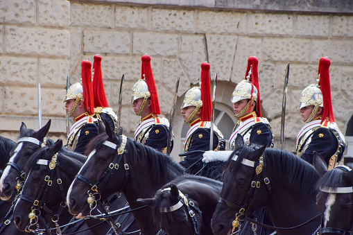 Changing the guard at Horseguards parade, Whitehall, London, England, UK, The guards are on horseback and in ceremonial outfits but are all serving soldiers in the British army.  In the foreground are armed policemen.