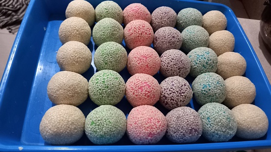View of colorful onde-onde with sesame topping, not yet fried, on a green tray