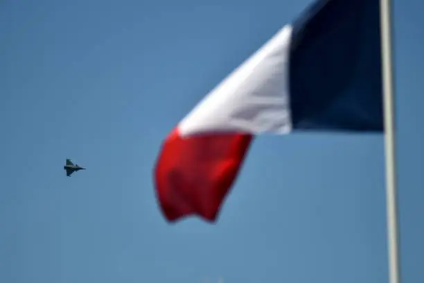Dassault Rafale fighter flying behind a French flag