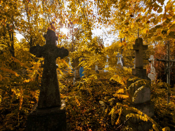 istock Sunny autumn cemetery. Abandoned stone crosses. 1826396521