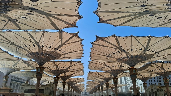 A wonderful view of Medina Haram Piazza Shading Umbrellas at the courtyard of the Prophet's Mosque in the bright day.