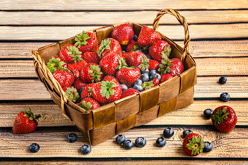 A basket with summer berries, strawberries and blueberries. Fresh harvest of berries