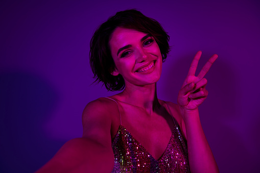 Photo of pretty lovely lady bachelorette celebrate prom event in night club make v sign selfie isolated neon color background.