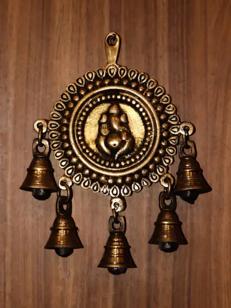 Photo of bronze bells with a decorative ganesh statue