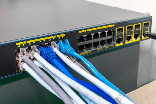 Network Gigabit Smart PoE Switch with  connected network cables getting tested on the desk