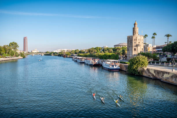 October 20, 2021 - Sevilla, Spain: Group of kayaks in the Guadalquivir River and the Golden Tower (Torre del Oro in Spanish) of Seville is a military watchtower in Seville, Spain. It is located on the shore of the Guadalquivir River and the most emblematic symbols of Seville. It was built between 1220 and 1221 and one of the oldest buildings in Seville, Spain.