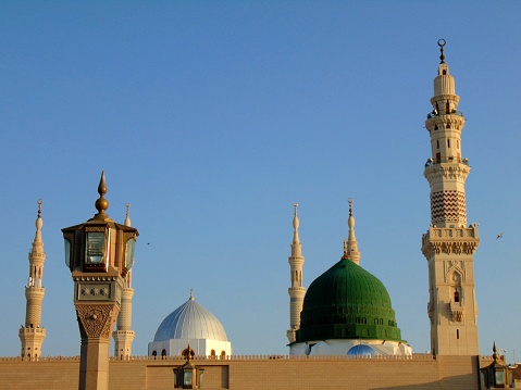 A majestic view of the Green Dome, the Silver Dome the minarets of the Prophet's Grand Mosque, al-Masjid an-Nabawi. The Green Dome is built above the tombs of the Prophet Muhammad, Abu Bakr, Umar, which is used to be the Noble Chamber of Aisha bint Abi Bakr.