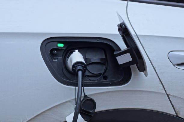 istock electric charging with a wire charges a white black electric car 1826510574