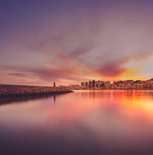 lighthouse and city skyline at sunset