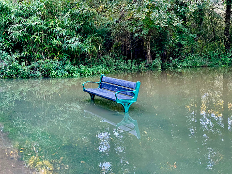 Flooded bench in a park in Norfolk after heavy rain. October 2023