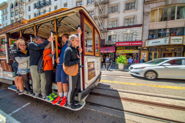 People ride the cable car in San Francisco, USA. Famous SF streetcars began operation in 1878.