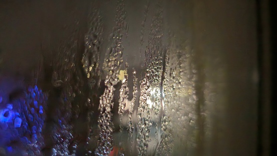 Condensation on the window dark outside with street lights.