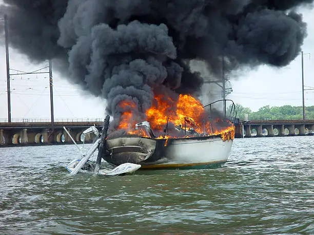 "Dramatic image of large (~40') sailboat which burned after having come in contact with overhead electrical lines. Maryland, USA"