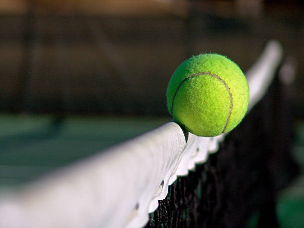 Bola de tenis atraviesa la red - foto de stock