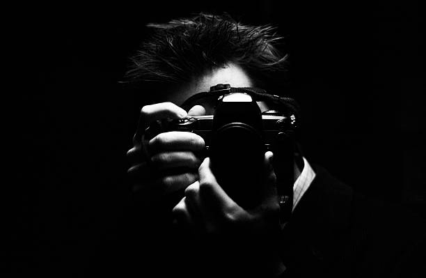 The Photographer * Self portrait in a gloomy lift. Nikon D1x file converted to black and white. High ISO file but the noise isn't too bad. Isolated on black black and white portrait photographers stock pictures, royalty-free photos & images